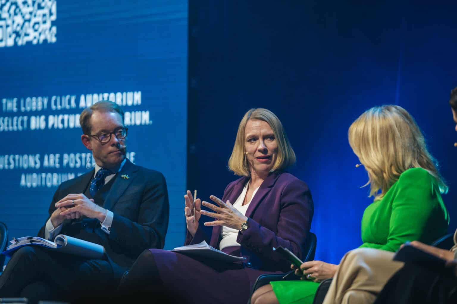 The image shows Anniken Huitfeldt, Foreign Minister of Knowledge, speak while two others in the panel listen.