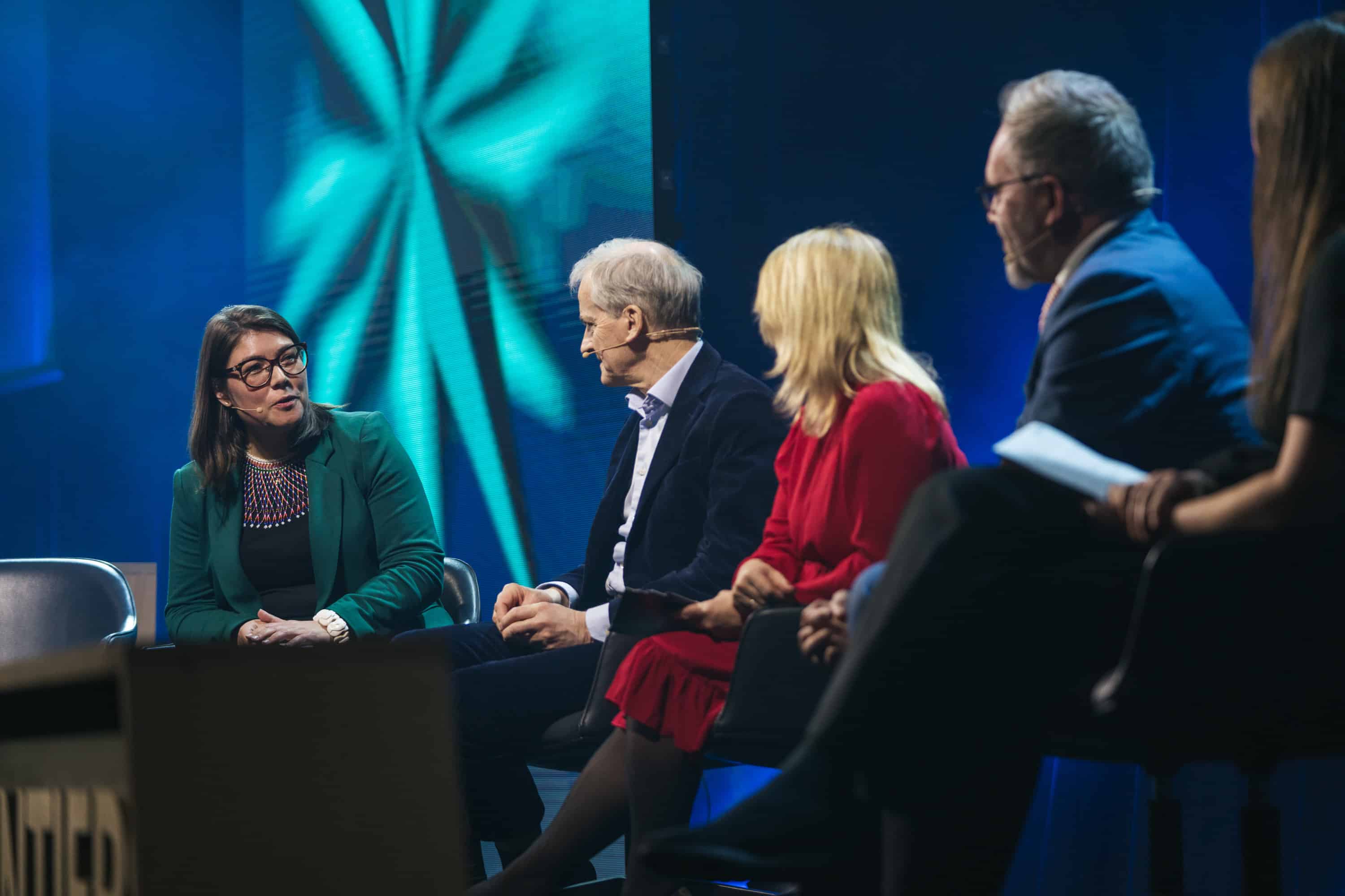 Image shows the Big Picture panel during AF 2023. A woman speaks while three others lean forward and listen.