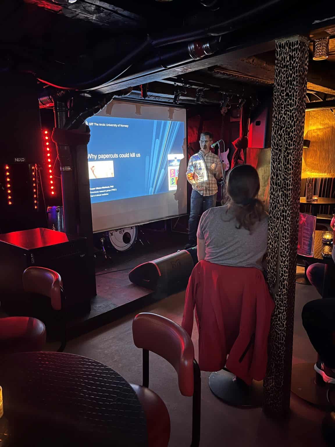 A scientist presents his work in a pub in Tromso.