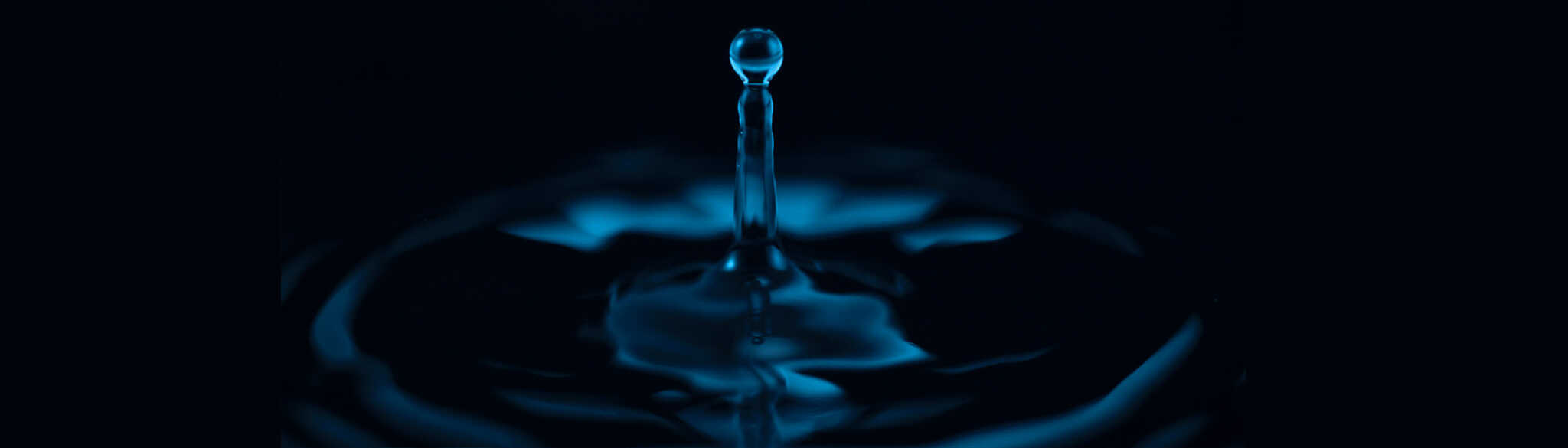 A water drop falls onto a puddle but the photo is upside down