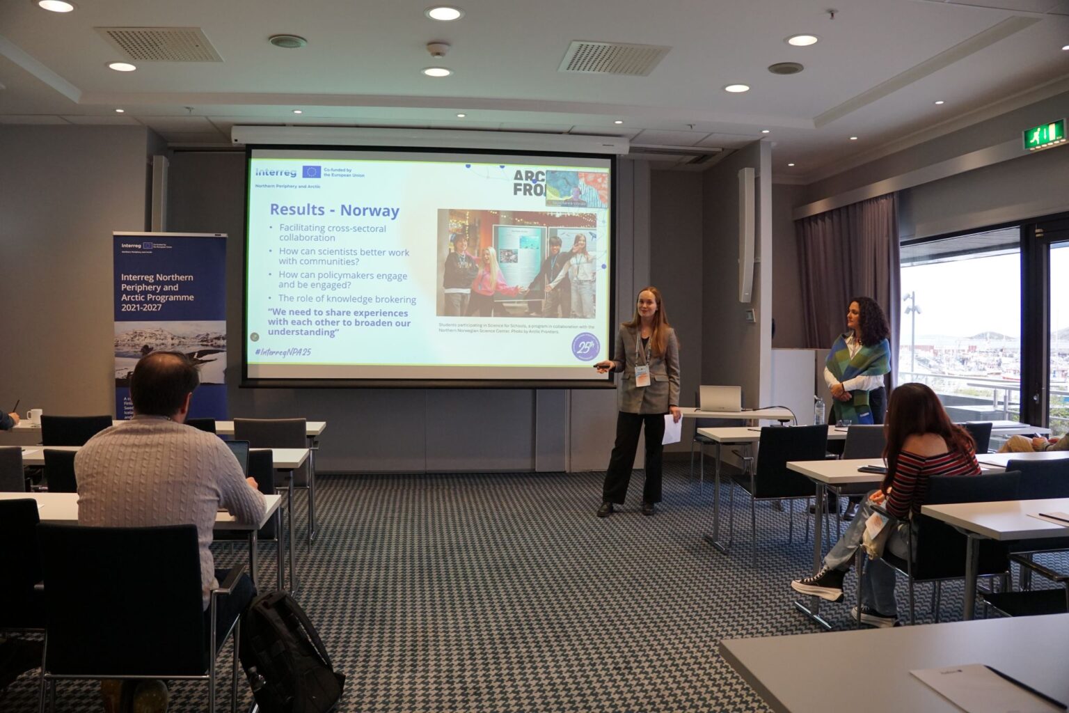 Arctic Frontiers - Two women present slides at the Arctic Frontiers - Capshare event to an audience in a modern conference room with large windows and natural light.