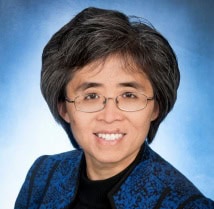 Arctic Frontiers - A smiling woman in glasses and a blue patterned jacket in the Arctic.