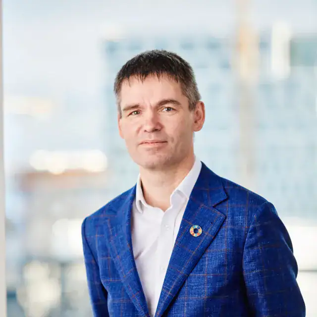 Arctic Frontiers - A man in a blue checked blazer and white shirt embodying Arctic resilience.